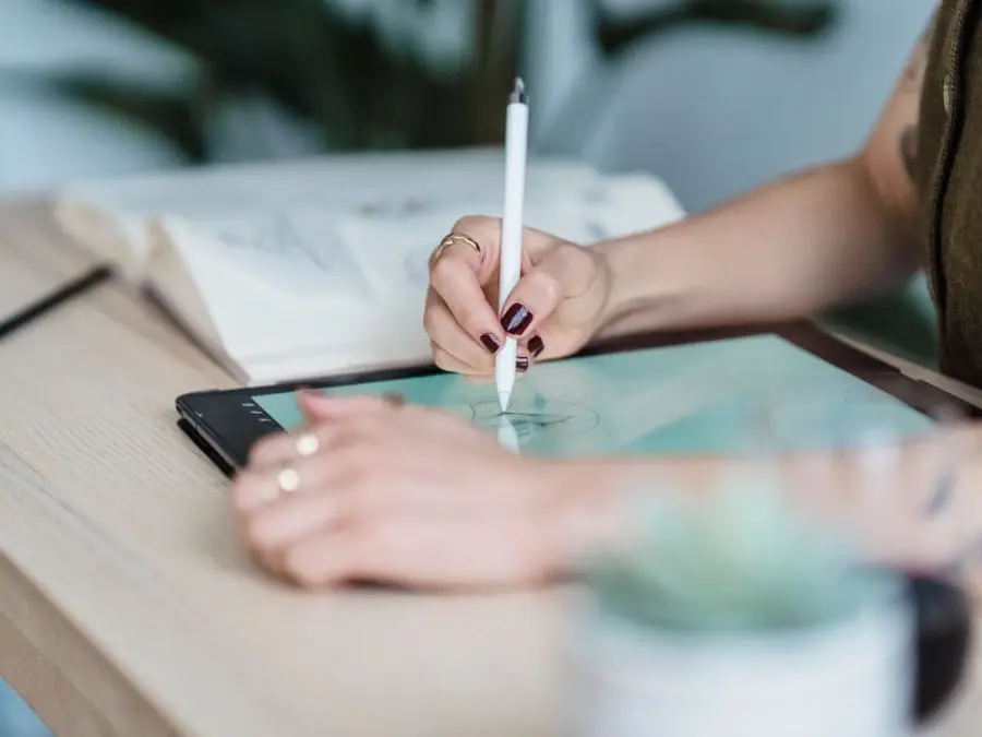 Tablet üzerinde kalemle logo çizen tasarımcı